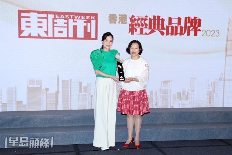 镛记酒家获颁「殿堂级品牌」大奖，由财务总监甘荞因（左）上台领奖。